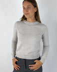 Lichtgrijs truitje in wol/cashmere in lichtgrijze tint. De ronde halsuitsnijding is voorzien van strass-details.