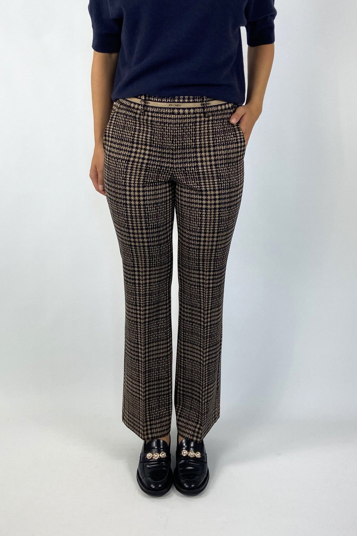 Deze broek in caramel met een donkerblauw ruitpatroon is voorzien van een comfortabele elastische tailleband. Riemlusjes, steekzakken en decoratieve paspelzakken achter.