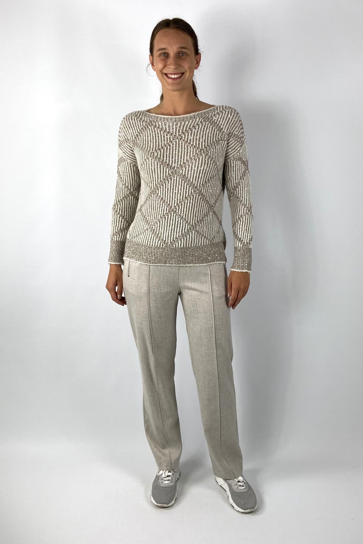 Beige gebreide pull met bicolor ruitpatroon. Het breiwerk is licht glinsterend.