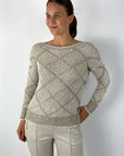 Beige gebreide pull met bicolor ruitpatroon. Het breiwerk is licht glinsterend.