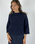 Donkerblauwe cashmere pull van FFC met een ruitvormig breipatroon.