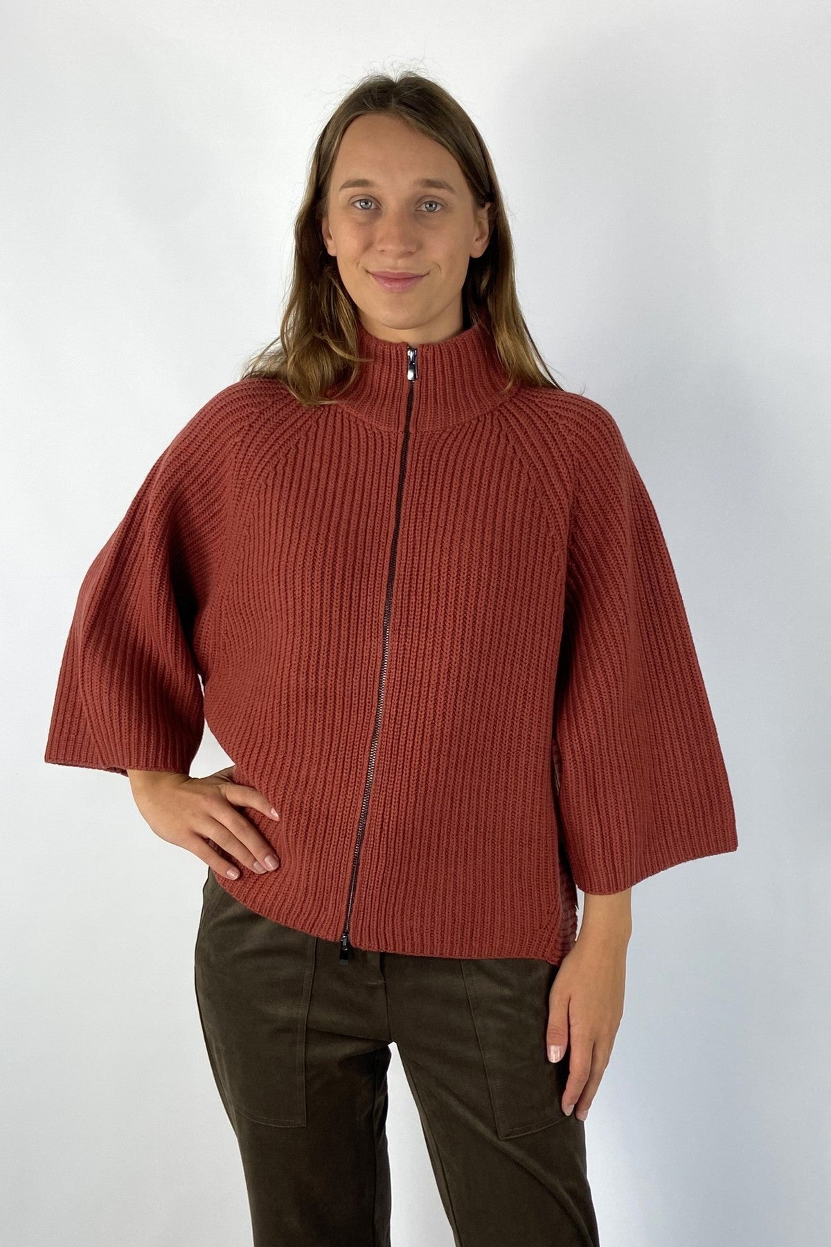 Gebreide vest met rits en opstaande kraag met 3/4 mouwen in een warme roestrode tint. De zachte wol/cashmere mix zorgt voor een aangenaam draagcomfort.