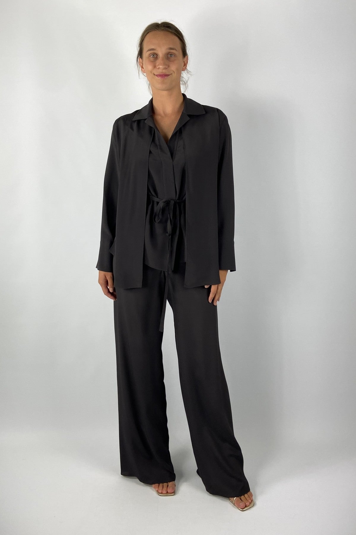 Shirtblouse in bruine kleur met lange mouwen en openvallende kraag. In de taille is een strikje voorzien. Deze blouse is uniek door het dubbele bovenpand.