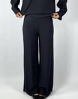Wijde rechte broek in zwarte travelwear-stof met micro-plissé. Comfortabel én elegant, ideaal voor zowel casual als chique momenten.