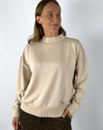 Lichtbeige sweater in modal kwaliteit met ribbrei details aan de zomen en de kraag.