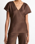 Satijnen blouse met V-hals en korte, zwierige kapmouwtjes in een vloeiend silhouet dat elegant valt over de heupen. Kleur: espresso bruin.