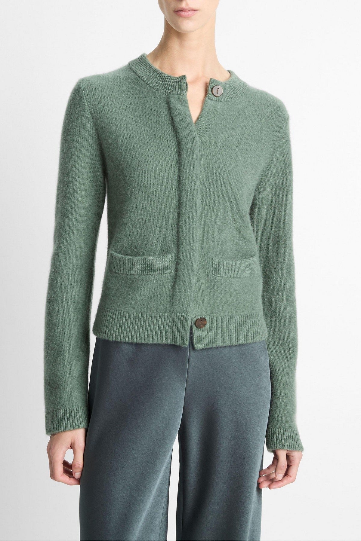 Klassiek kasjmier vest in lindegroen van Vince met verborgen knoopsluiting. Zacht, warm en tijdloos met steekzakken en ribdetails
