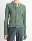 Klassiek kasjmier vest in lindegroen van Vince met verborgen knoopsluiting. Zacht, warm en tijdloos met steekzakken en ribdetails