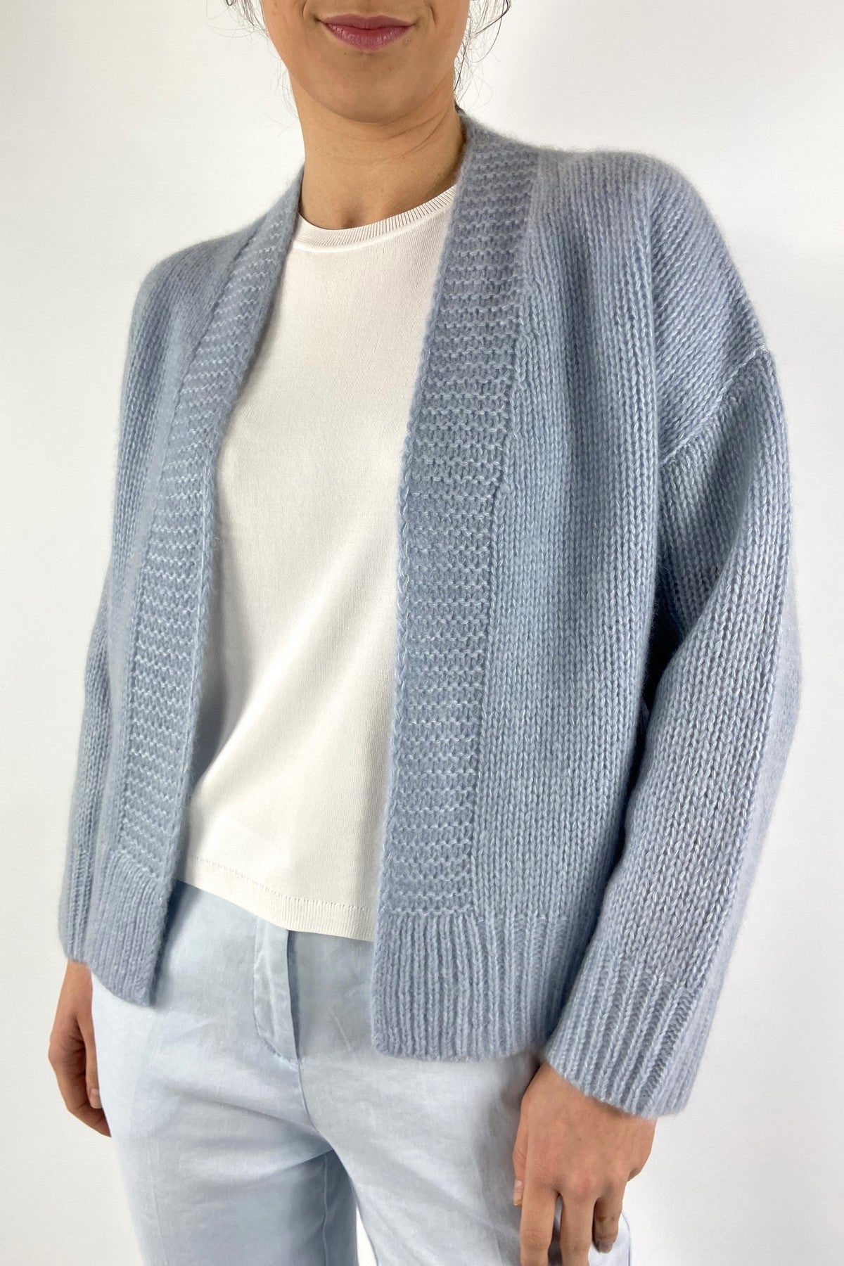 15042-1539: Detail van het verfijnde fantasiebreiwerk op de boorden van de FFC cardigan in kleur Ciel.
