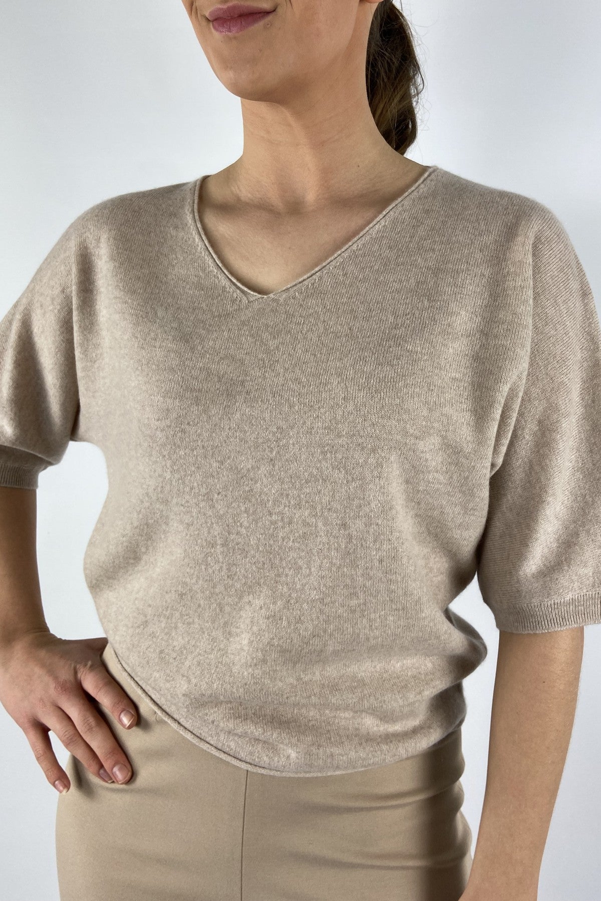 15053-1080: Detail van de fijne wol-cashmere breistructuur en de diepe V-hals van de beige FFC trui.