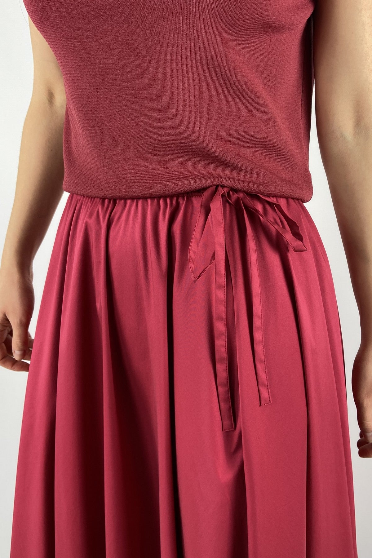 15425 Detail van FFC A-lijn rok granaatrood met elastische tailleband en plooien.