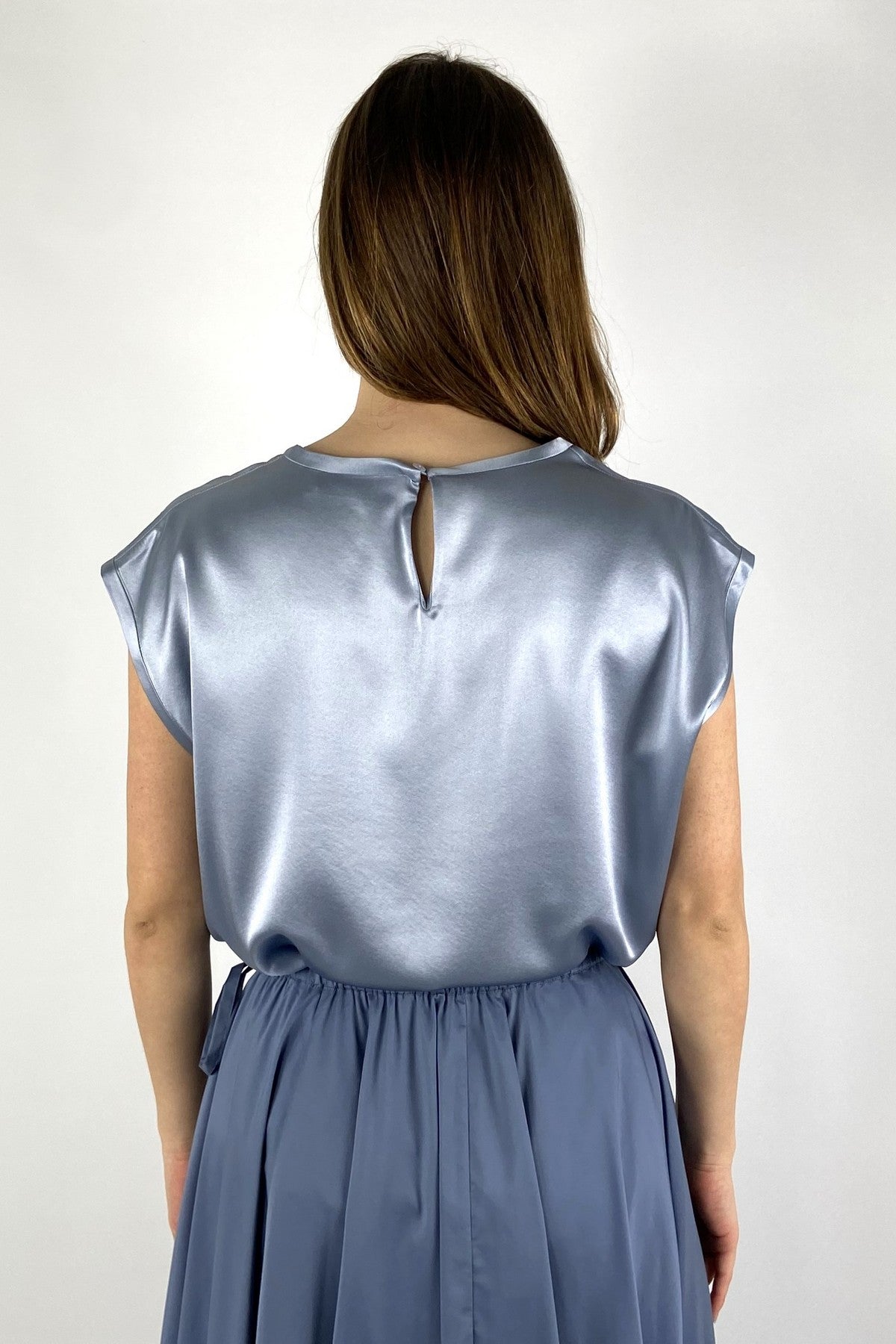 15452 Detail van FFC top in lichtblauw met glans en knoopje in de nek.