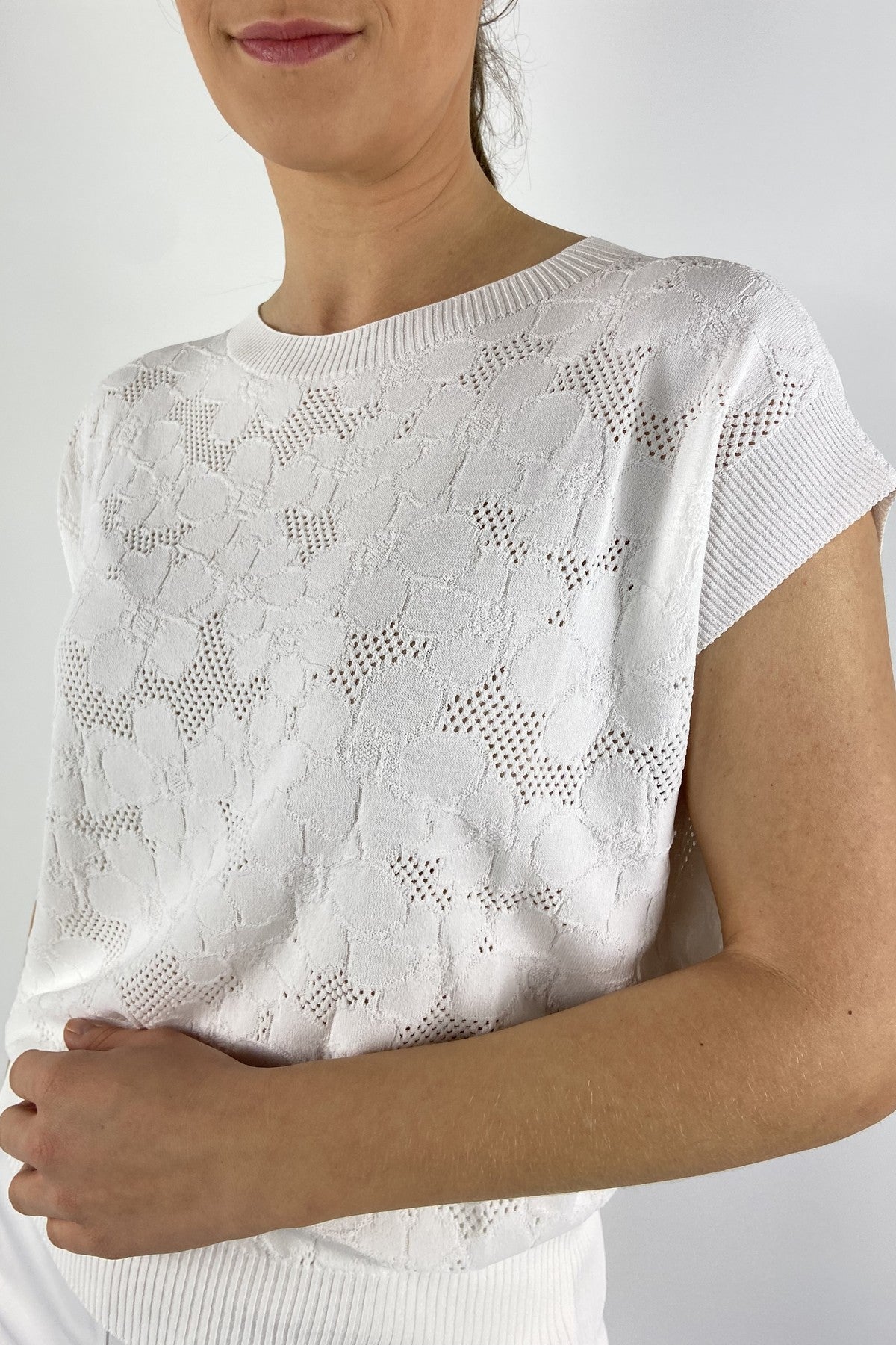 62056-1: Detail van de kapmouwen en het verfijnde bloemdessin in het witte breiwerk van D.Exterior.