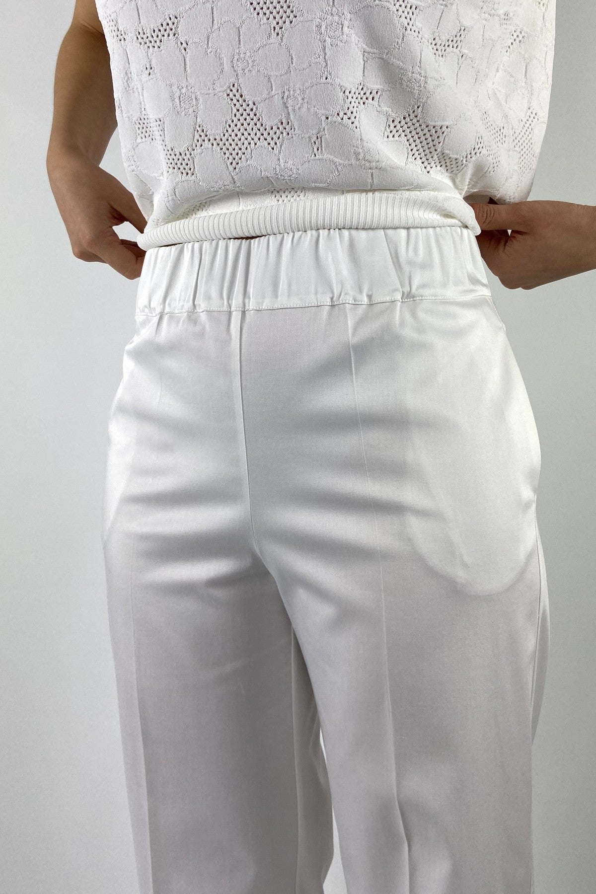 62791-1: Detail van de elastische tailleband en de lichte glans van de witte D.Exterior broek in kleur 1.