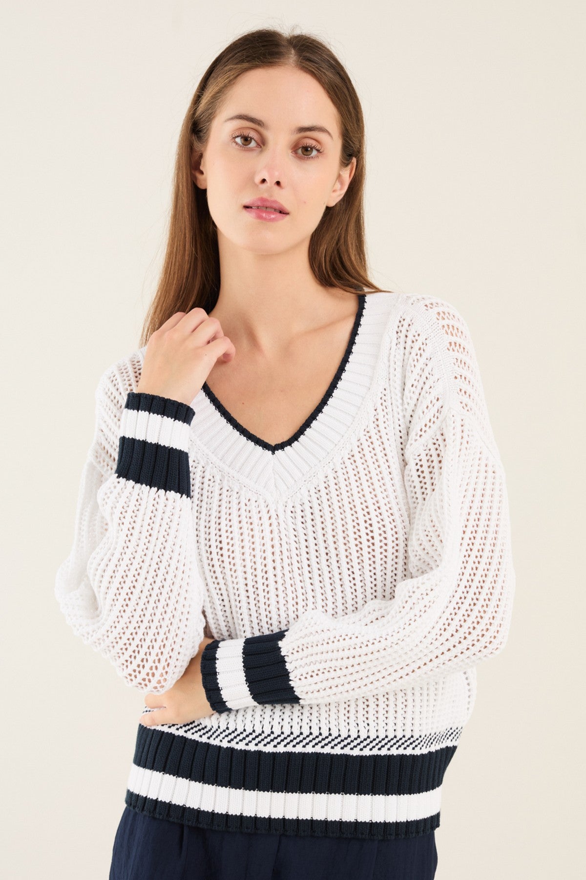 Witte Anneclaire trui met V-hals en donkerblauwe streep onderaan.