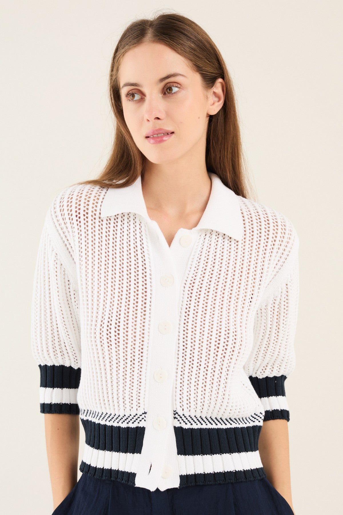 Wit gebreid vest van Anneclaire met knopen, polokraag en blauwe streepjes.