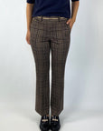 Deze broek in caramel met een donkerblauw ruitpatroon is voorzien van een comfortabele elastische tailleband. Riemlusjes, steekzakken en decoratieve paspelzakken achter.
