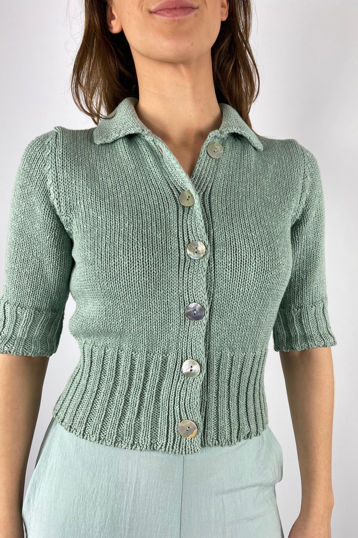 D1605-938 Detail van de grove breistructuur en knoopsluiting van het Anneclaire vest aqua.