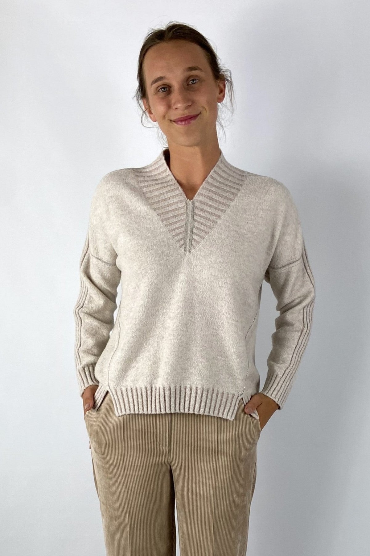 Zachte crèmetrui met V-hals en relaxte pasvorm voor een stijlvolle, comfortabele look, perfect te combineren met broek, rok of jeans.