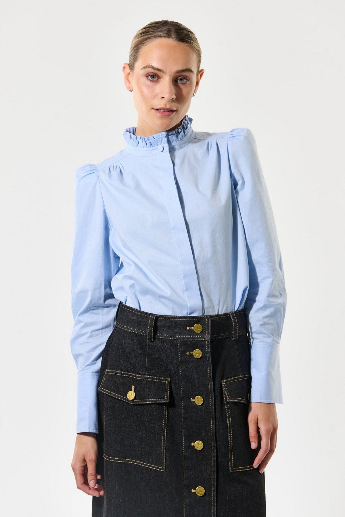 Elegant satijnzijden blouse van Dea Kudibal in lichtblauw met ruches, pofmouwen en decoratieve knopen. 