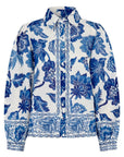 Witte linnen blouse met een gedurfde blauwe florale print, volumineuze mouwen en contrasterende biezen langs de knoopsluiting.
