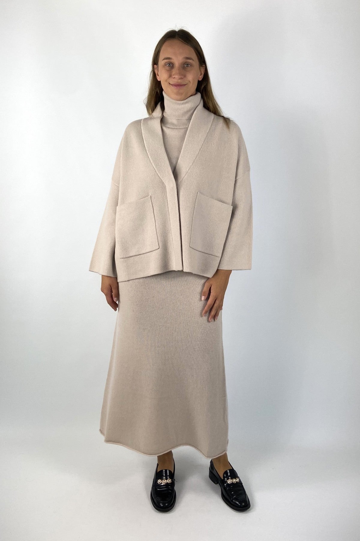 Cardigan van FFC met opgestikte zakken en lange mouwen. De kleur is lichtbeige.