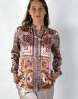 Een rechte damesblouse van zijde met print in ecru roze en burgundy. De blouse heeft een hoge hals, knoopjes vooraan en lange mouwen die verstelbaar zijn.