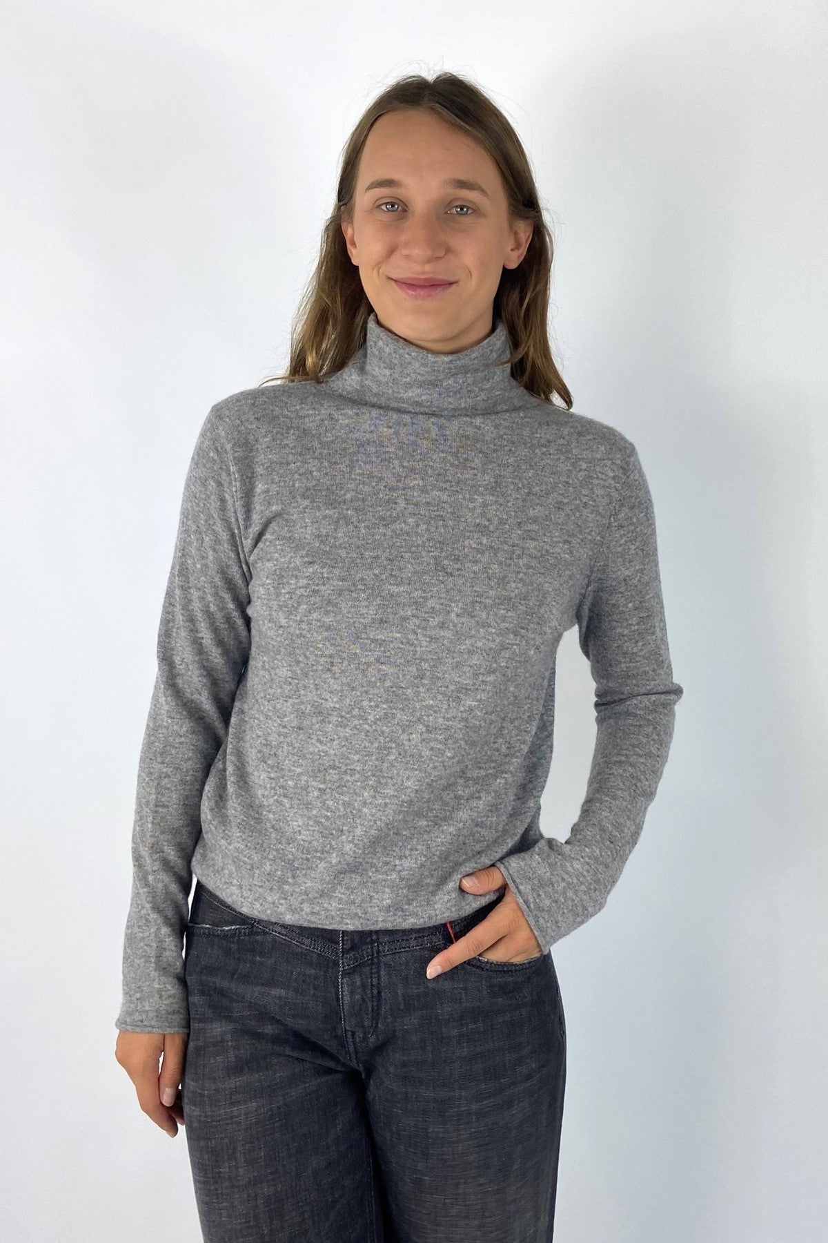 Truitje met rolkraag in middengrijs die uitzonderlijk zacht en aangenaam voelt door de 100% cashmere brei.
