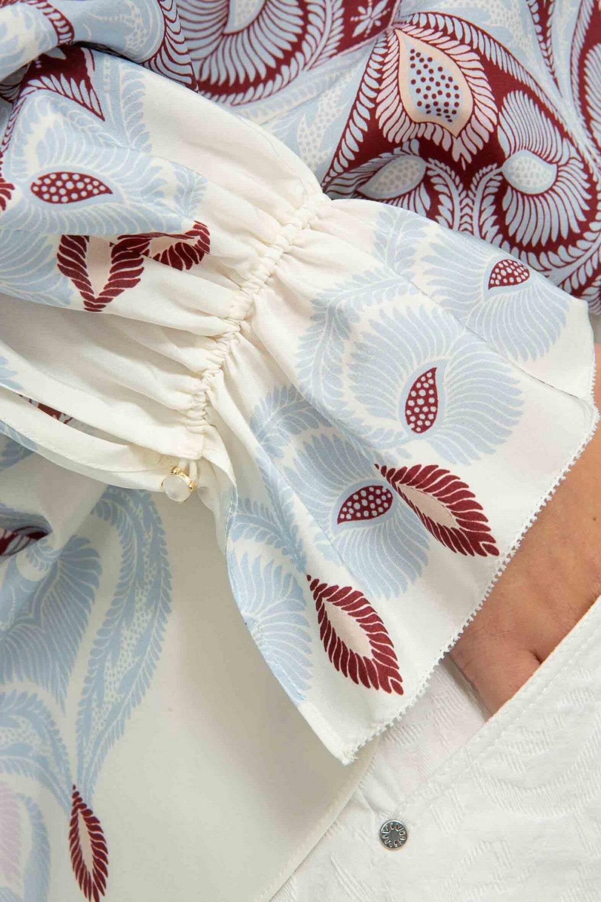 26201013: Detail van de elastische mouwmanchetten met ruches en de zijde-stretch stof in wijnrode en blauwe tinten van de IVI Collection tuniek.