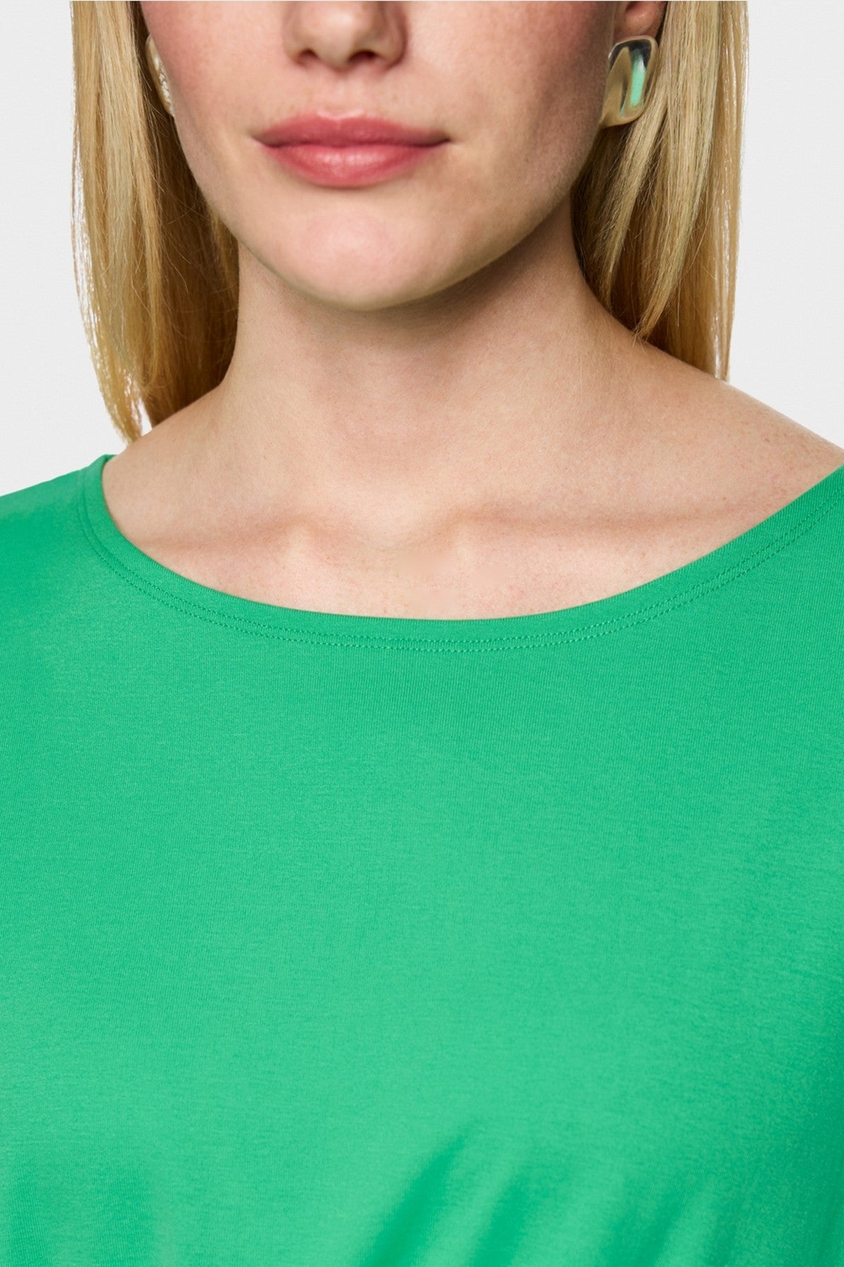 Close-up van de stretchkatoen kwaliteit en de aangeknipte mouw van het Marc Cain shirt.