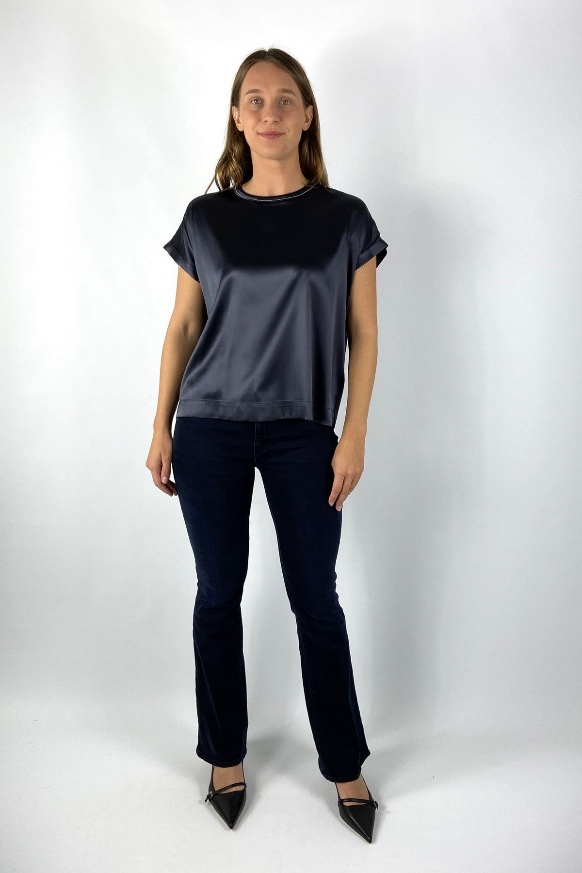 Een donkerblauw damesjeans in bootcut model. De broek heeft een middelhoge taille, een strakke pasvorm aan de heupen en dijen en licht uitlopende pijpen tot aan de enkels.