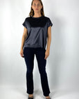 Een donkerblauw damesjeans in bootcut model. De broek heeft een middelhoge taille, een strakke pasvorm aan de heupen en dijen en licht uitlopende pijpen tot aan de enkels.