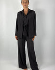 Shirtblouse in bruine kleur met lange mouwen en openvallende kraag. In de taille is een strikje voorzien. Deze blouse is uniek door het dubbele bovenpand. 