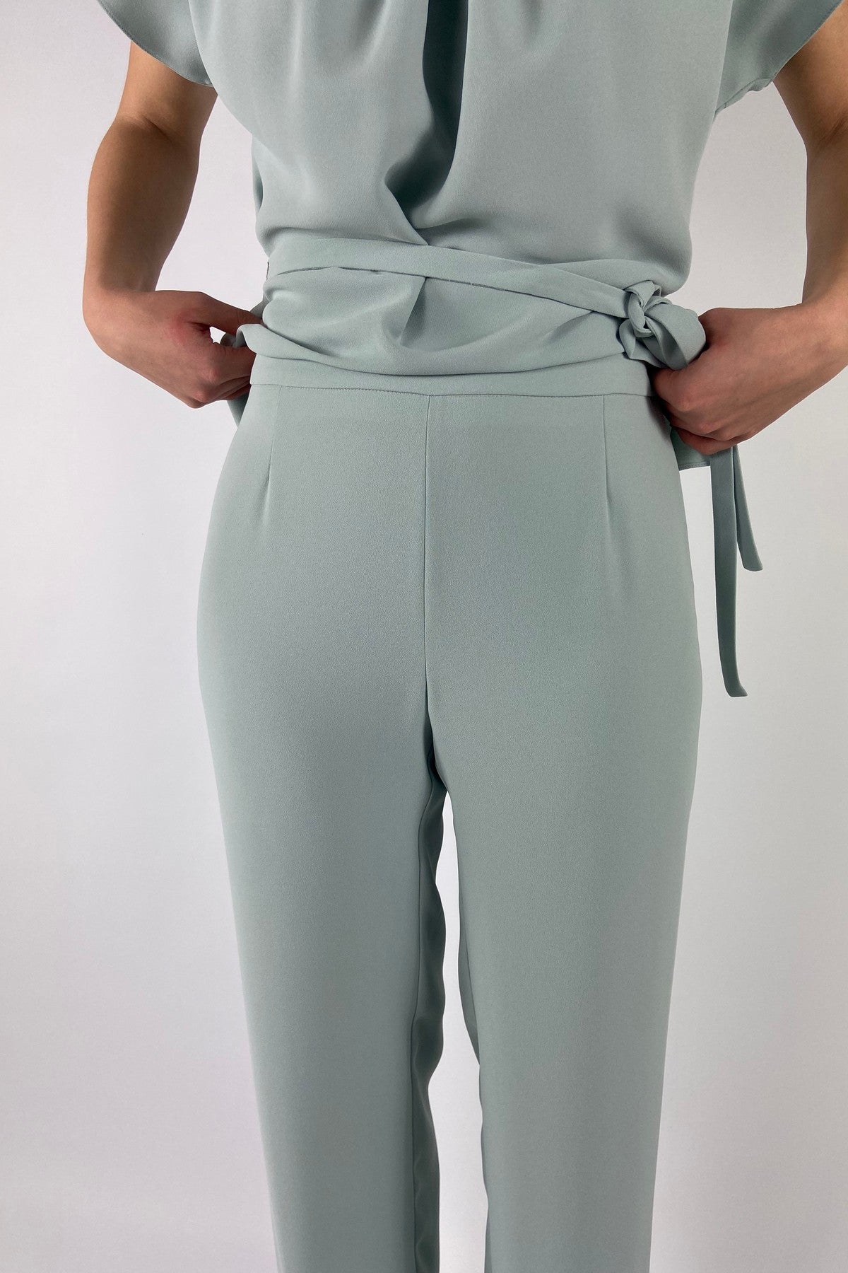 Close-up van de luxe mintkleurige crêpestof van de Natan Ezra broek in kleurcode driehonderdvierenveertig.
