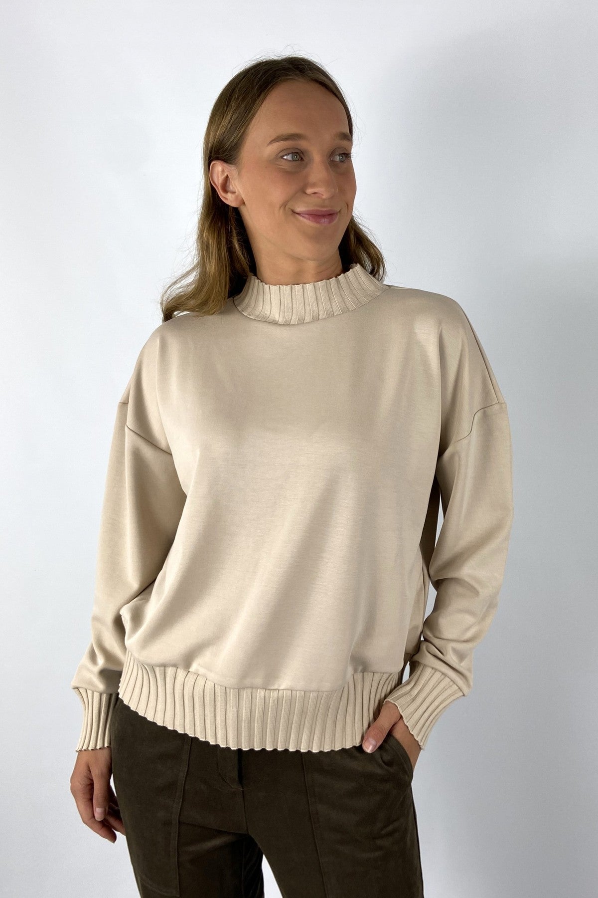 Lichtbeige sweater in modal kwaliteit met ribbrei details aan de zomen en de kraag.