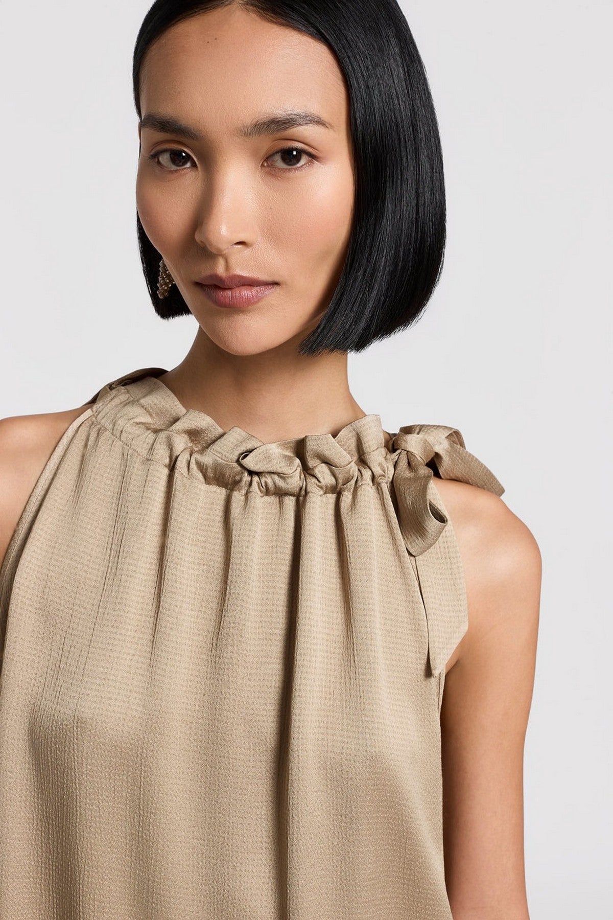 Close-up van de gehamerde textuur van de Peserico satijnen top. Snelle verzending in NL, BE & DE.