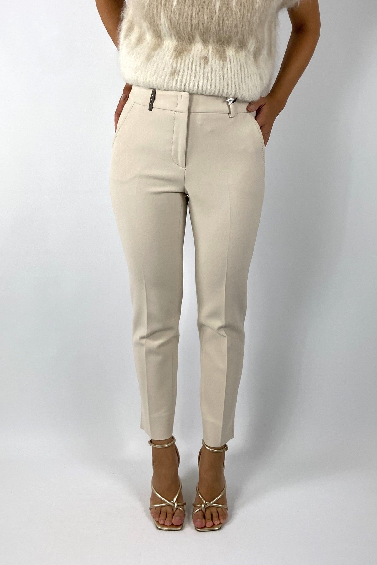 Enkellange lichtbeige Peserico broek met normale taille, riemlussen, rits- en haaksluiting. Slim fit met zadelsteken en paspelzakken achter.