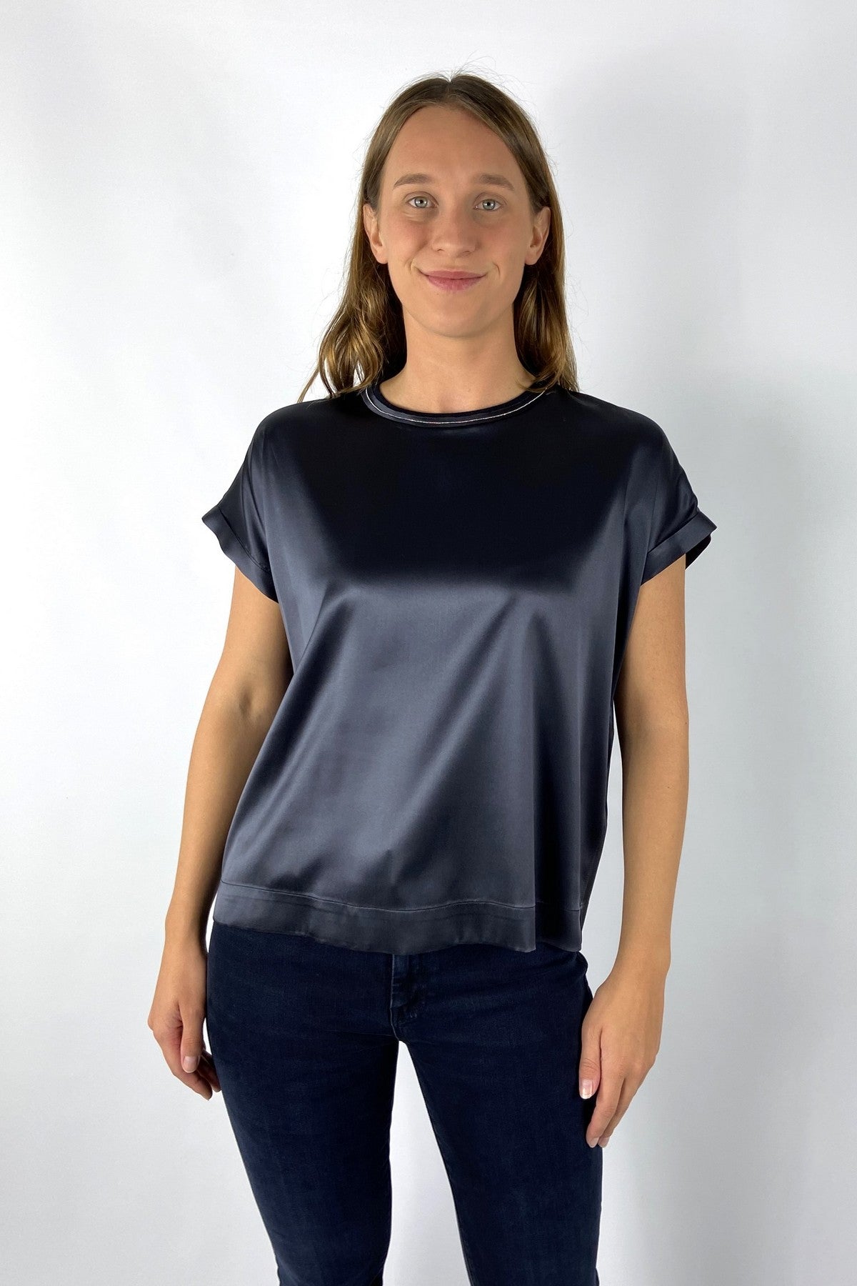 Een glanzend dames-T-shirt in zijde satijn met korte, wijde kimonomouwen. Aan de halslijn schittert een subtiel glinsterend detail. De snit is losjes met een licht uitlopende zoom.